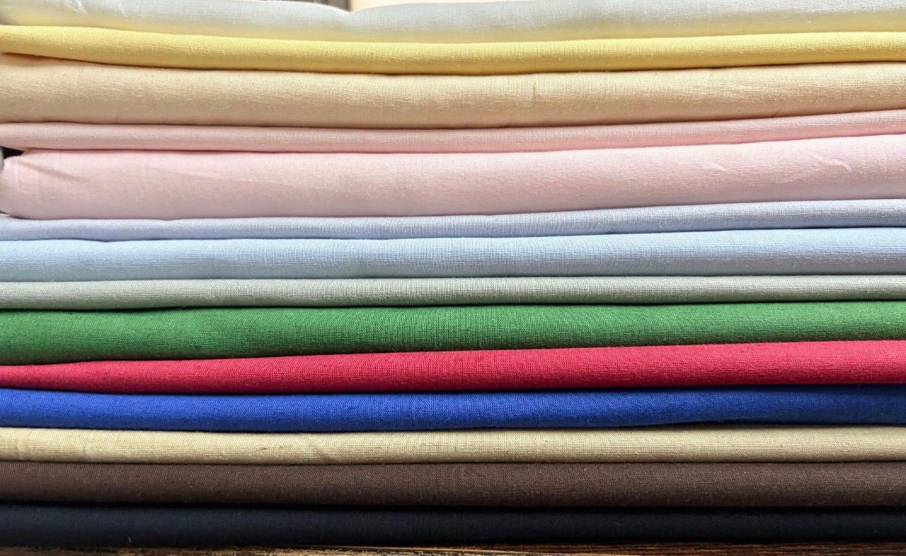 Stacked premium printed fabrics in soft pastel tones